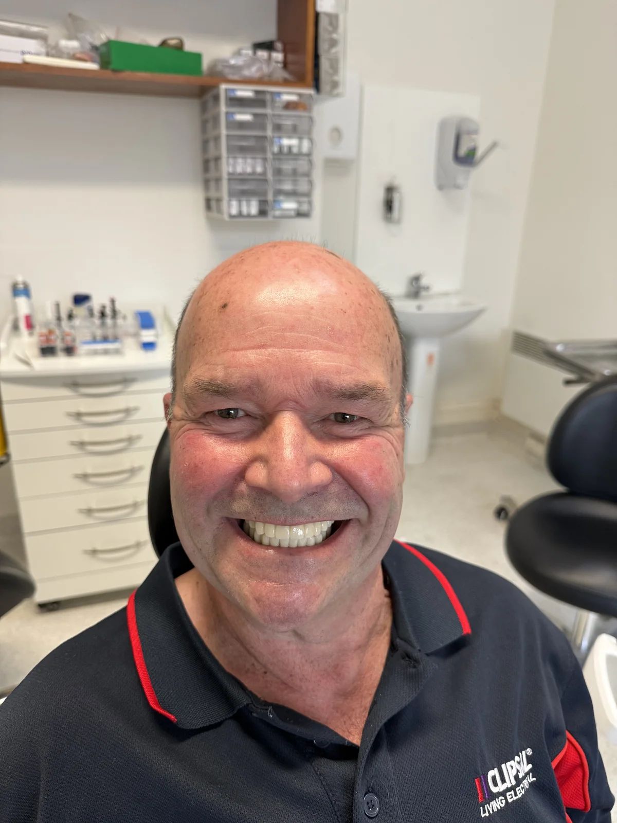 Full face photo of a smiling Hobart Dental Implant Clinic patient after full arch implant treatment